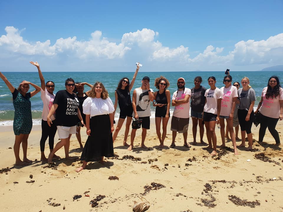 Group poses on a sunny beach by the sea